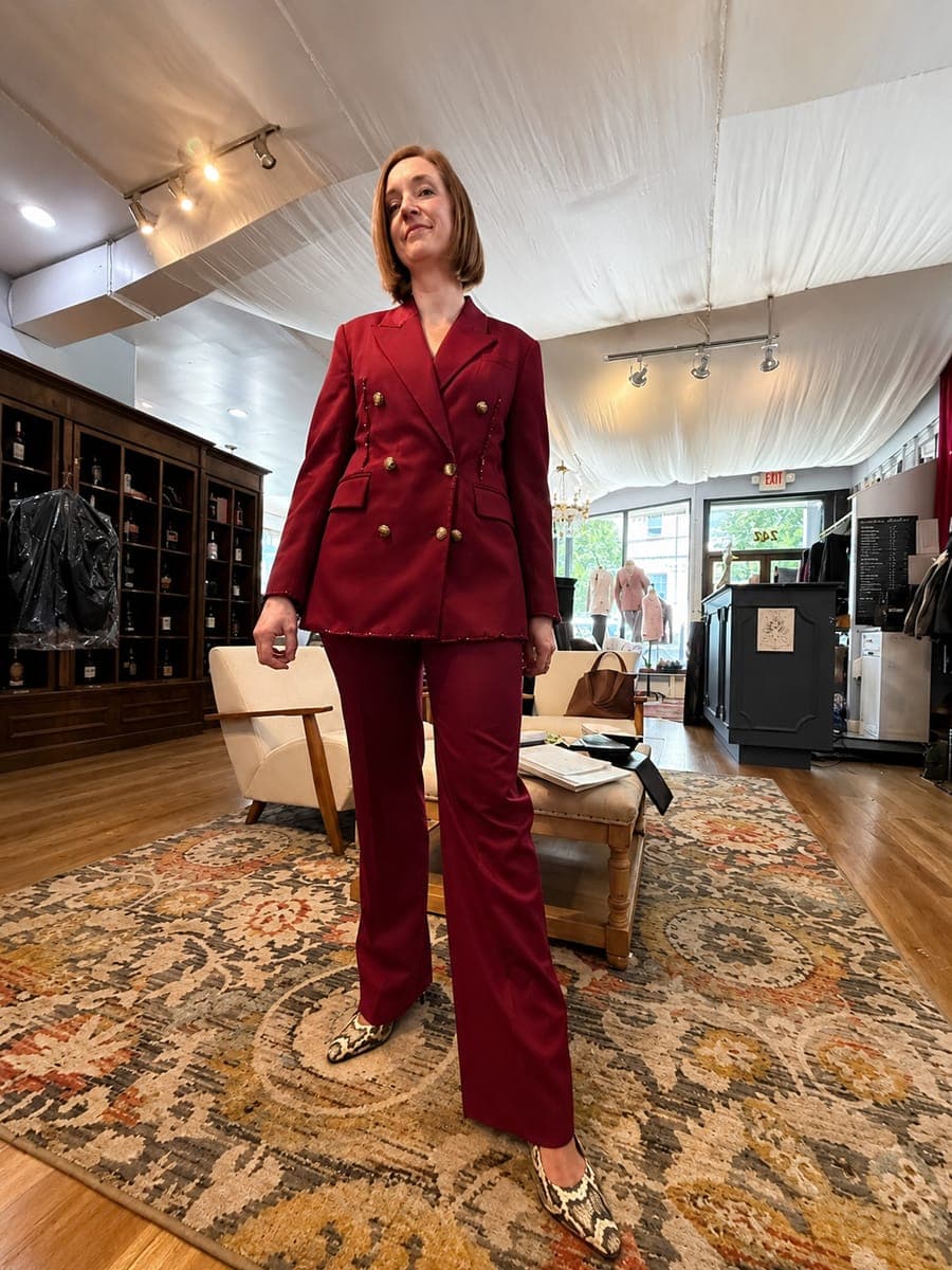 A client in a deep red double-breasted trouser suit on the shopfloor